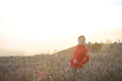 Portrait of woman on field against sky during sunset