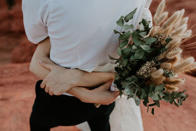 Midsection of woman holding flower bouquet