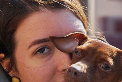 Close-up portrait of young woman with dog outdoors