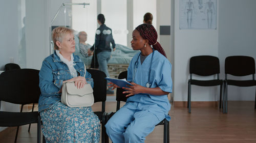 Nurse talking with senior patient in clinic