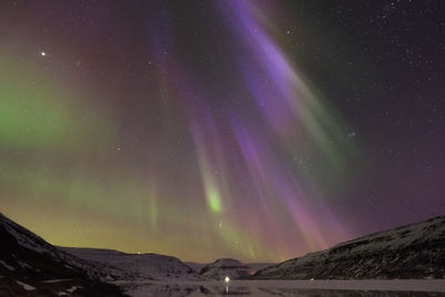 Scenic view of snowcapped mountains against sky at night