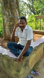 Portrait of young man sitting on land