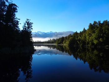 Scenic view of lake against clear blue sky