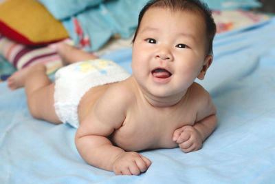 Portrait of cute baby lying on bed