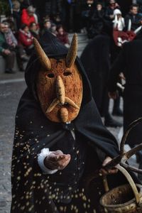 Person wearing costume with bucket on street in city