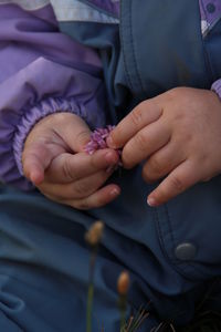 Close-up of baby holding a clover flower.