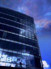 Low angle view of modern building against cloudy sky