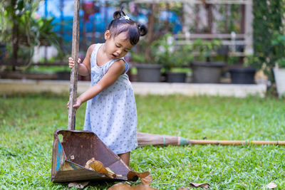 Cute girl cleaning backyard