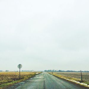 Empty road passing through field