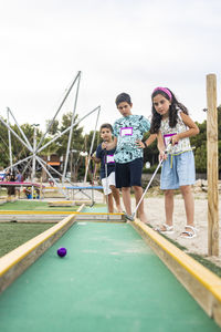 Cute kids playing golf outdoors