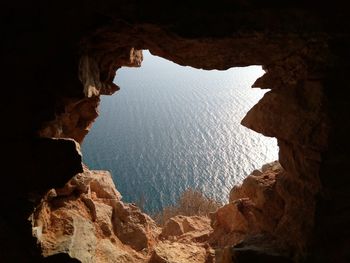 Rock formations by sea against sky