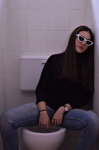 Beautiful young woman sitting in bathtub