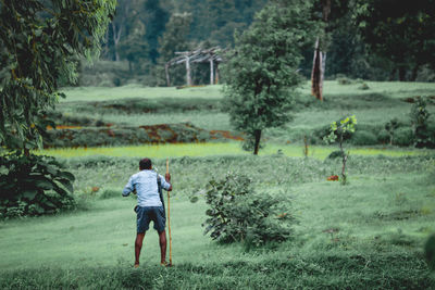 Rear view of man standing on grassy land