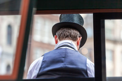 Rear view of man standing in bus