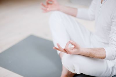 Low section of man doing yoga in studio