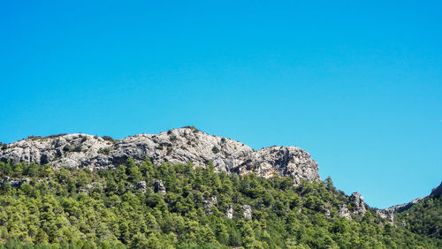 Low angle view of mountain against clear blue sky