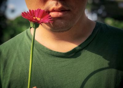 Close-up of woman with pink flower