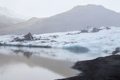 Beautiful silent landscape of glacier sólheimajökull with tranquil water and misty air, iceland.