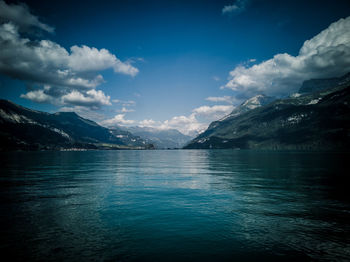 Scenic view of lake and mountains against blue sky