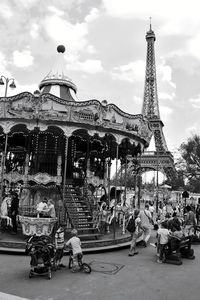 People at amusement park with eiffel tower in background