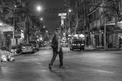 Man walking on illuminated street at night