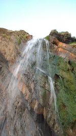 Scenic view of waterfall against clear sky