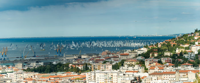 Aerial view of town by sea against sky