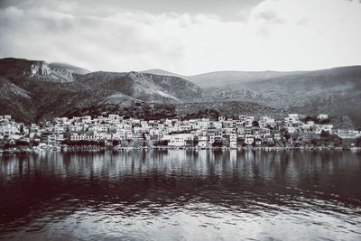 Scenic view of lake by buildings against sky