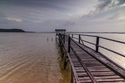 Pier on sea against sky during sunset