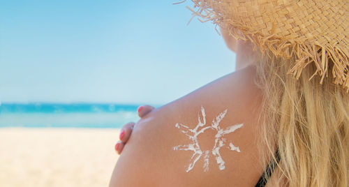 Close-up of woman on beach against sky