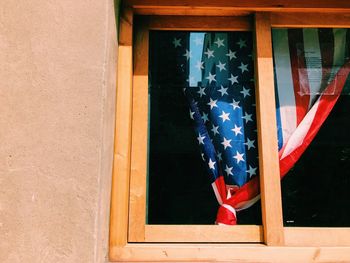 Low angle view of american flag curtain seen from window glass