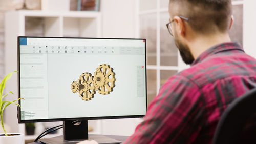 Side view of man using laptop at office