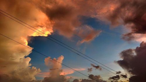 Low angle view of silhouette electricity pylon against sky during sunset