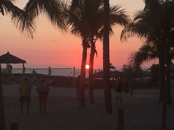 Silhouette people at beach during sunset