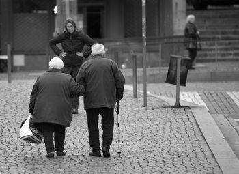 Rear view of couple walking on street