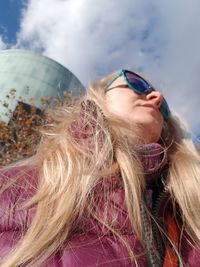 Low angle view of woman in sunglasses against sky