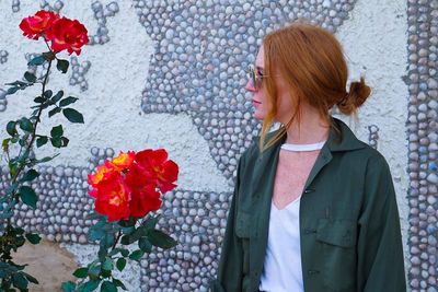 Woman with red flowers in the background