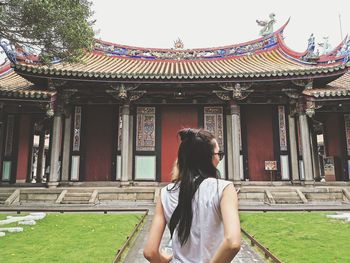 Woman standing against building