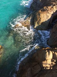 High angle view of sea by rocky cliffs