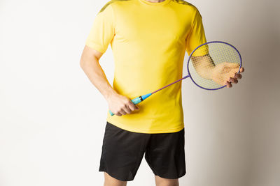 Midsection of man holding yellow while standing against white background