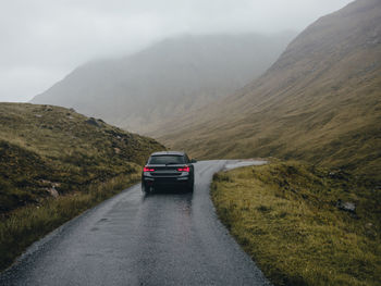 Car driving on road through glen etive