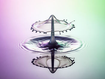 Close-up of water splashing against colored background