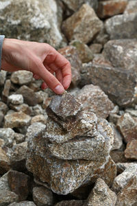 Cropped hand of woman adjusting stone stack