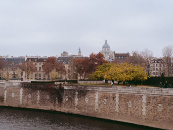 Buildings at waterfront against sky