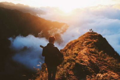 Man with guitar on mountain peak