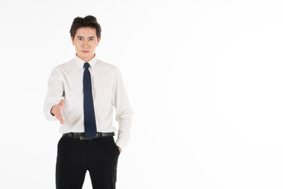 Portrait of young man standing against white background