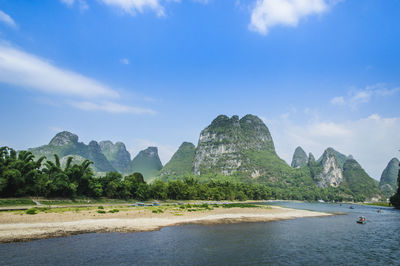 Scenic view of sea and mountains against sky