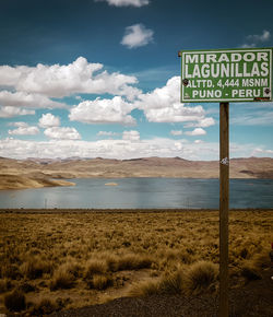 Information sign on land against sky