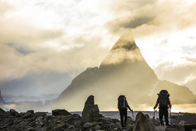 Rear view of backpackers approaching dramatic mountain, mt. loki