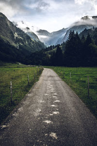 Road amidst green landscape against sky